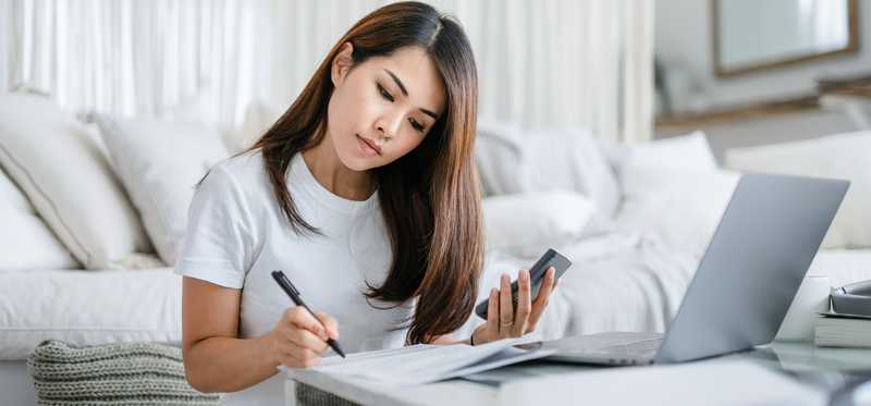Person sitting on floor and using coffee table to work and write.