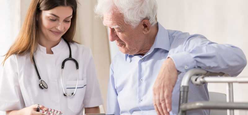 Nurse giving patient medicine.