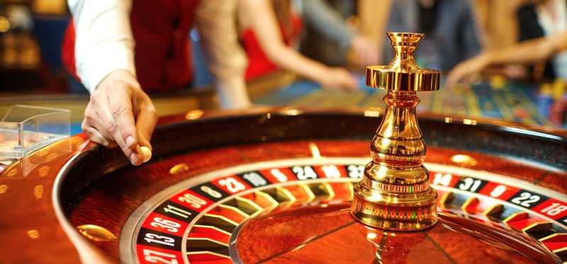 A roulette wheel and casino worker.