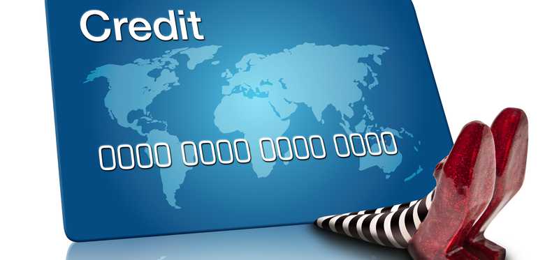 Ruby slippers being crushed by a credit card.