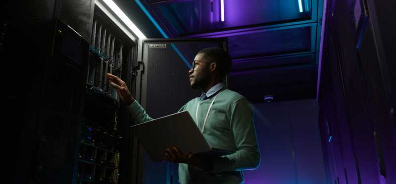 A person working at a server rack in a data center.