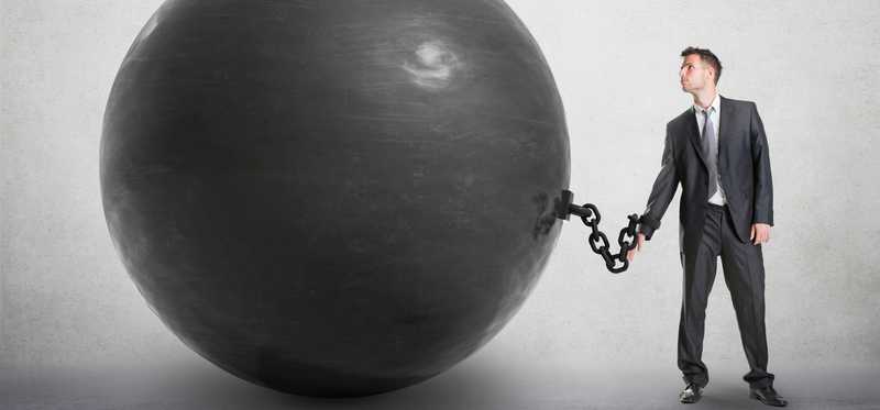 A man is chained to a huge ball.