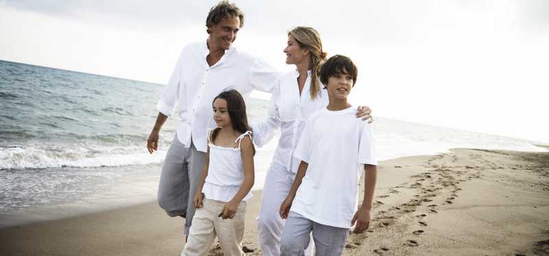 Couple with two children walking on the beach.