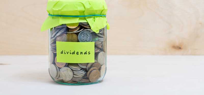 Jar full of coins labeled dividends.