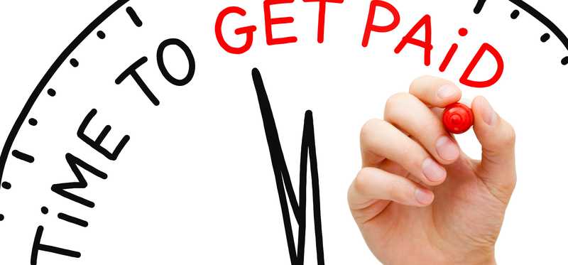 Time to get paid being written out in marker on a clock.