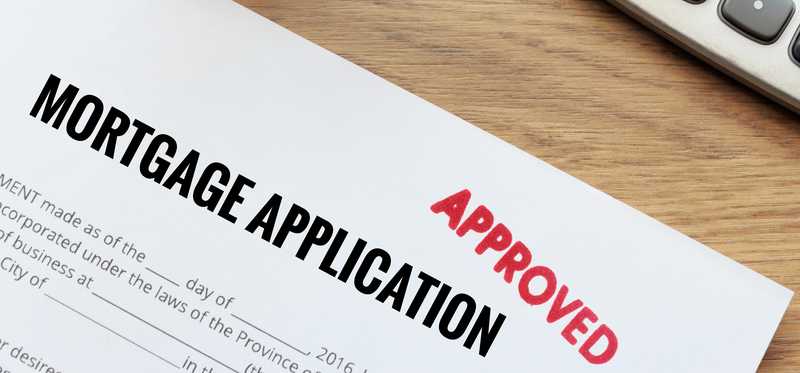 Mortgage application with red approved stamp.