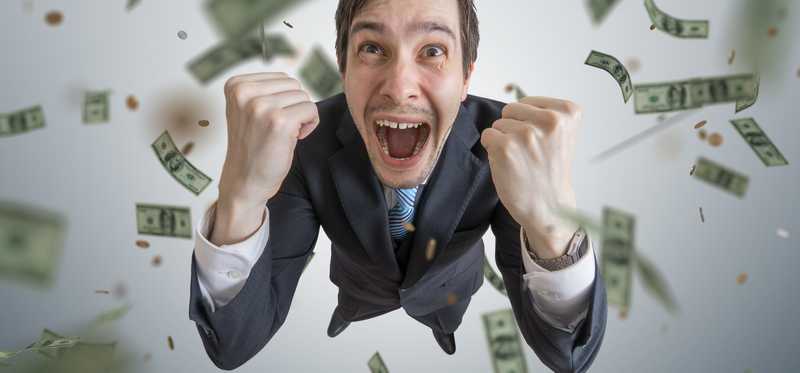 Person celebrating as money rains down.