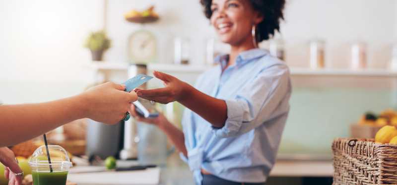 Cashier taking credit card payment from a customer in a shop.