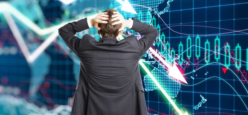 Person with hands on head is looking at a graph of a market crash.