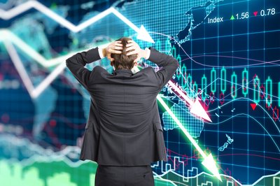 Person with hands on head is looking at a graph of a market crash.
