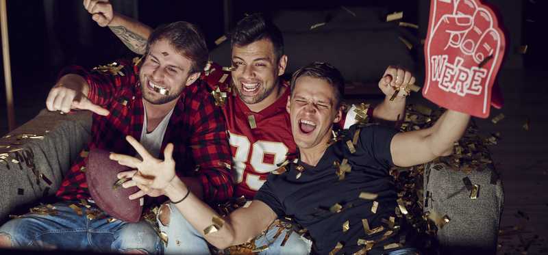 Men watching football on a television.
