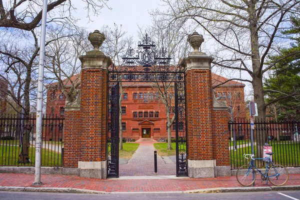 Brick pillar and wrought iron fence entrance to Harvard.