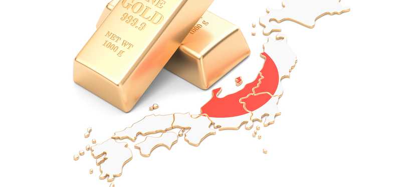 Gold bars atop map of Japan.