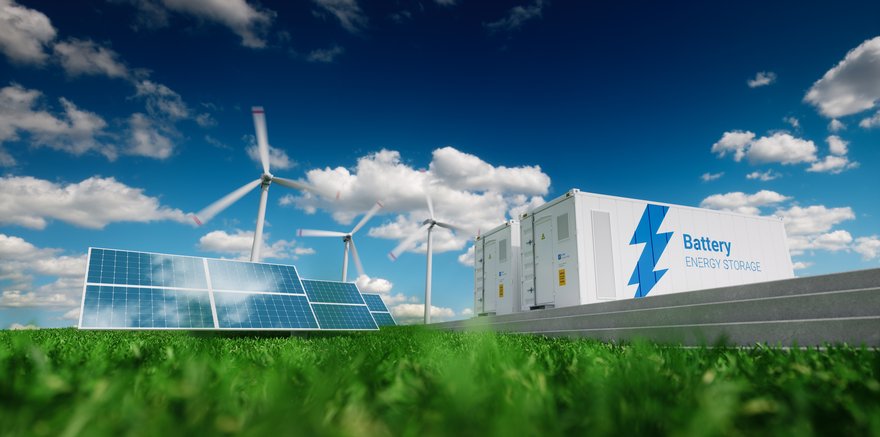 Wind, solar, and battery power lying on green grass.