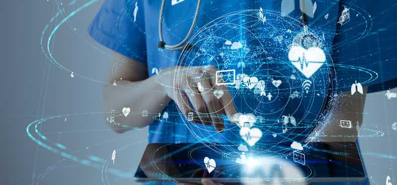 a doctor in scrubs holding a tablet with a globe made of digital images above the tablet