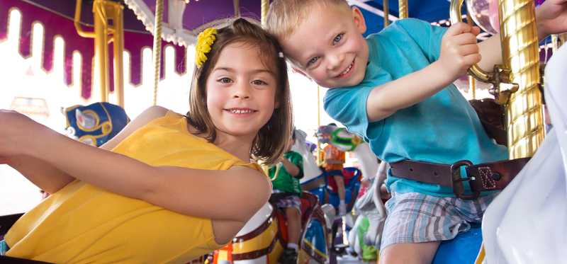 a young boy and girl on a merry go round