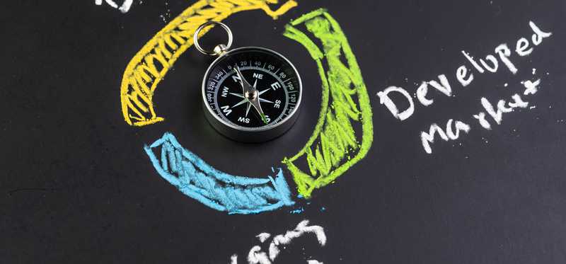 A compass in the middle of several asset class category names written in colors.