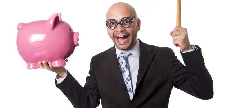 A man in a suit with thick glasses acting oddly and holding a hammer and piggy bank.