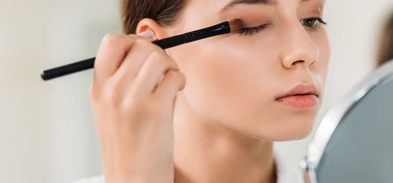 A woman applying eyeshadow.