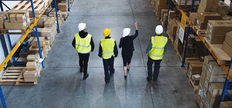 Long shot of four people in a warehouse.