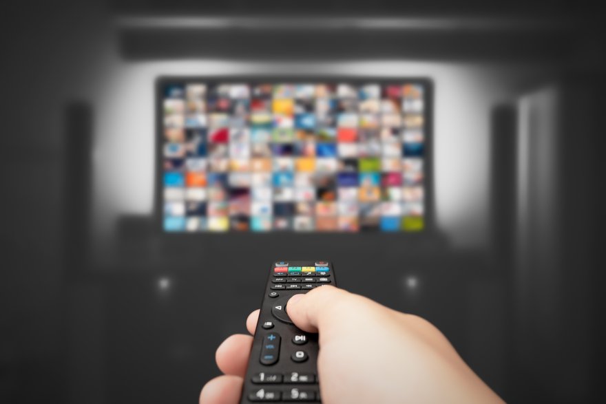 Person holding remote and streaming shows.