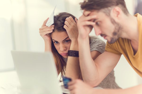 Two stressed out people looking at laptop.