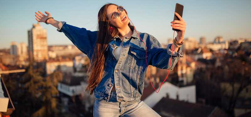 Woman taking a selfie on a smartphone while on a rooftop