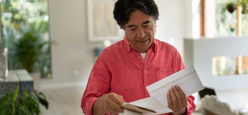 Person standing and looking through mail.