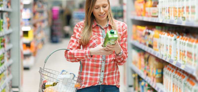 Woman looking at the label on a container in the store