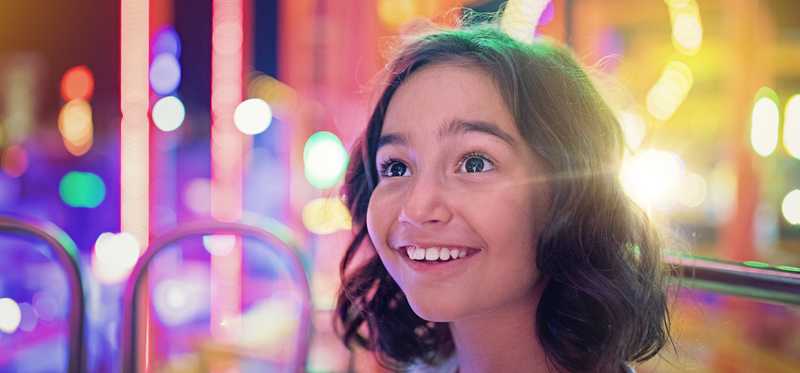A person smiling at an amusement park.