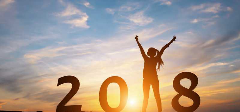 Silhouette at sunset of a woman as the "1" in "2018"