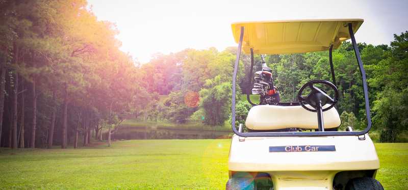 A golf cart sitting on a green course.