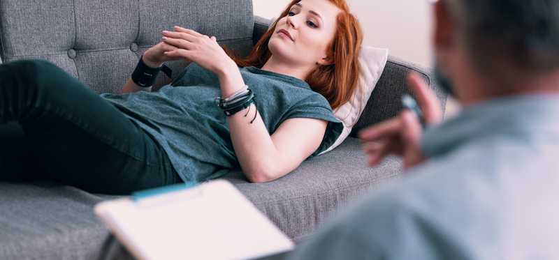 A woman lying on a couch doing talk therapy