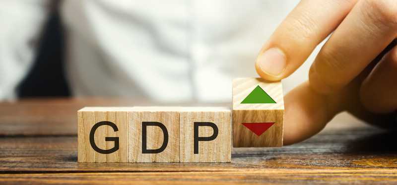 A person sitting in front of blocks spelling GDP.