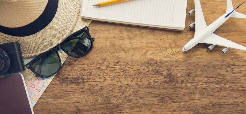 Table with hat, sunglasses, documents, and model airplane.