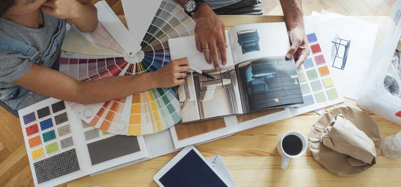 A couple looks at design books to choose paint colors, etc.
