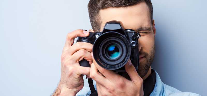 A man holding a camera to his face.