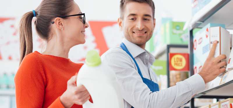 A supermarket clerk helps a customer.