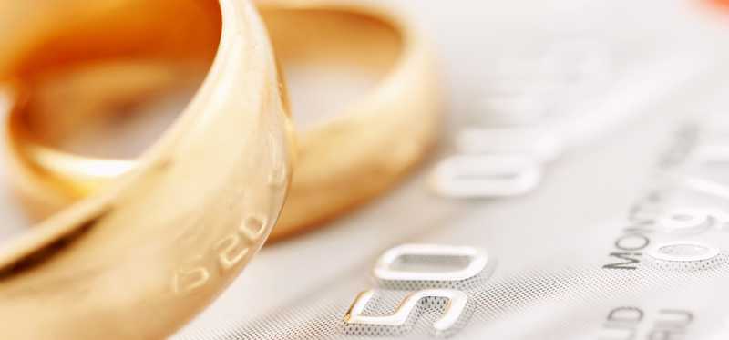 Two gold wedding rings atop a credit card.