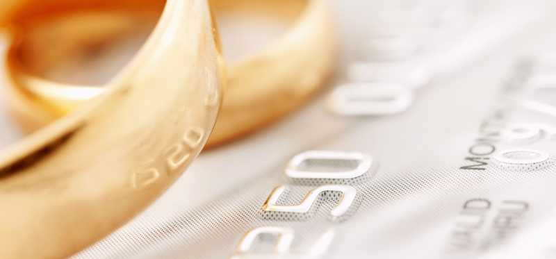 We see two gold wedding rings atop a credit card.