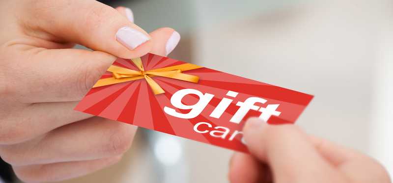 One person handing a gift card to another person