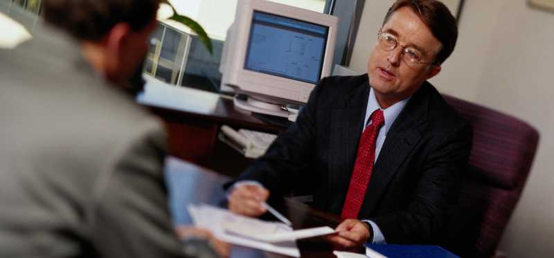Man sits at a desk and talks with a professional.
