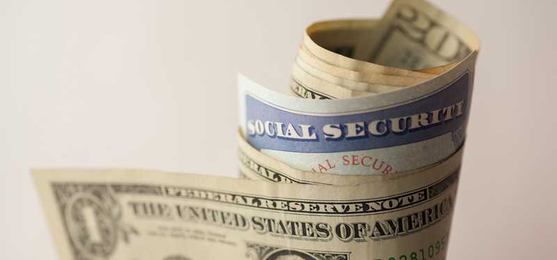 A person holding hundred dollar bills fanned out.