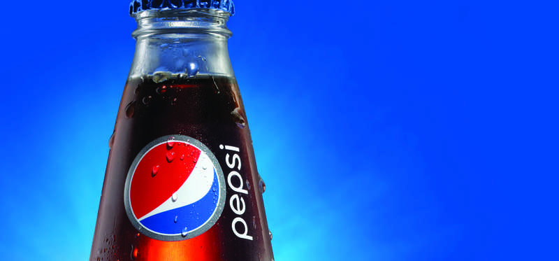 A glass Pepsi bottle over blue background.