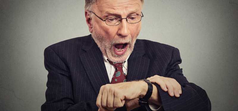 We see an older man looking at his watch in alarm, as if he's very late.