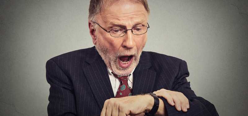 Person looking at watch in alarm.