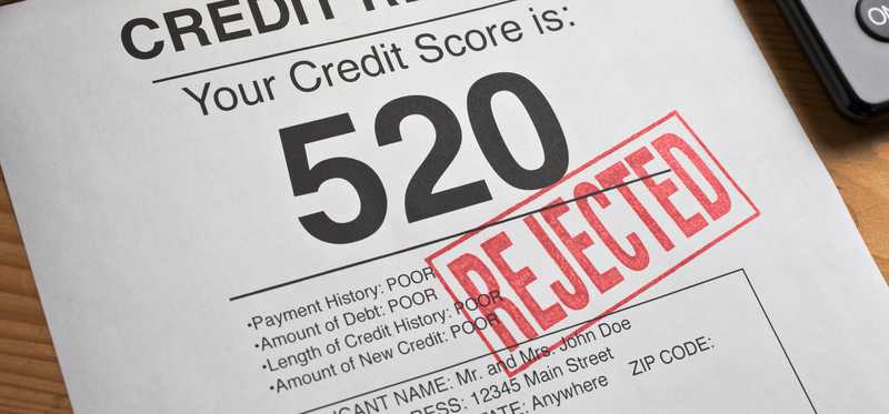 We see a credit report with a credit score of 520 in big print and the word rejected is stamped across it in red.