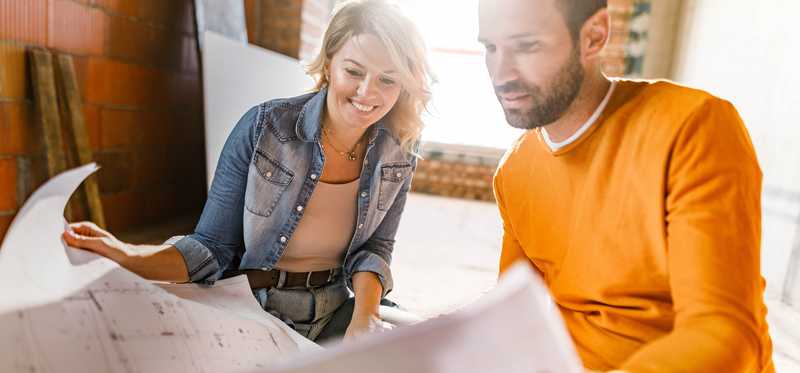 Couple looking at design plans for house.