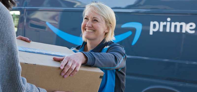 Amazon delivery worker hands a box to a customer.