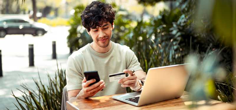 Person shopping online while seated outside.